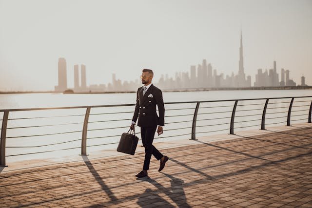 a man walking on a sidewalk with a briefcase